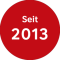 Auf einem roten Kreis steht mit weißer Schrift "seit 2013".