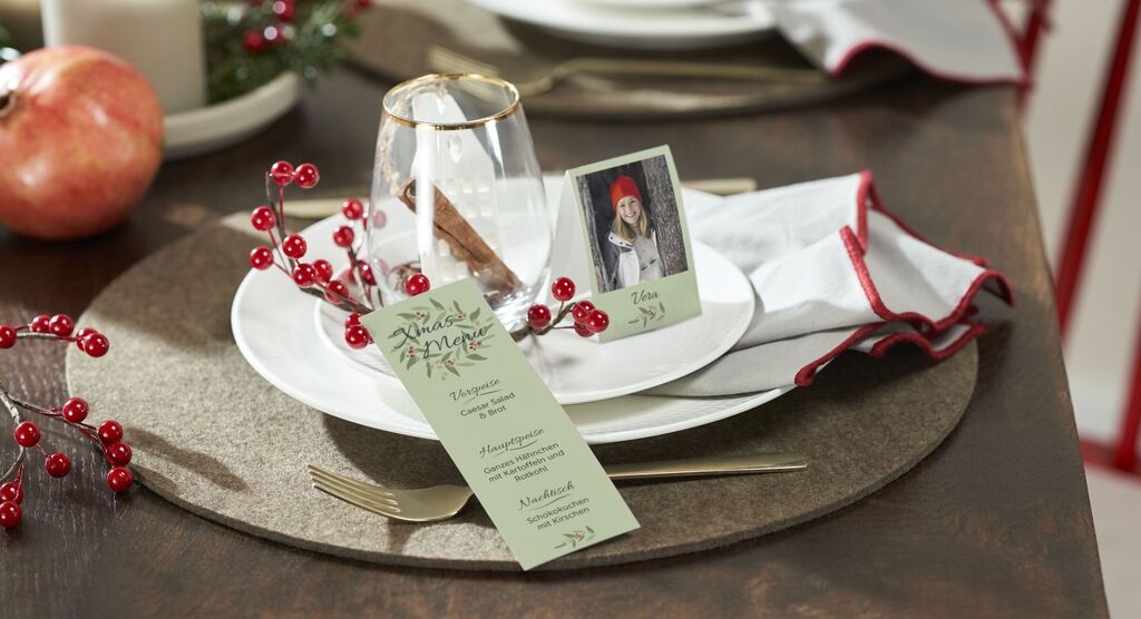 Elegante Tischdekoration mit festlichem Menüplan und kleinen Fotos.