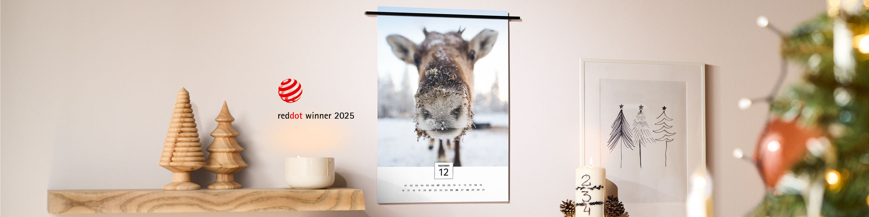CEWE Kalender in modernem Design, an einer stilvoll dekorierten Wand mit Kerzen, Holztannen und Weihnachtsbaum