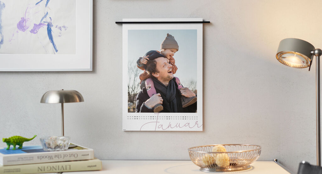 Wandbild mit einem fröhlichen Kind und aufgerolltem Kalender für den Monat Januar