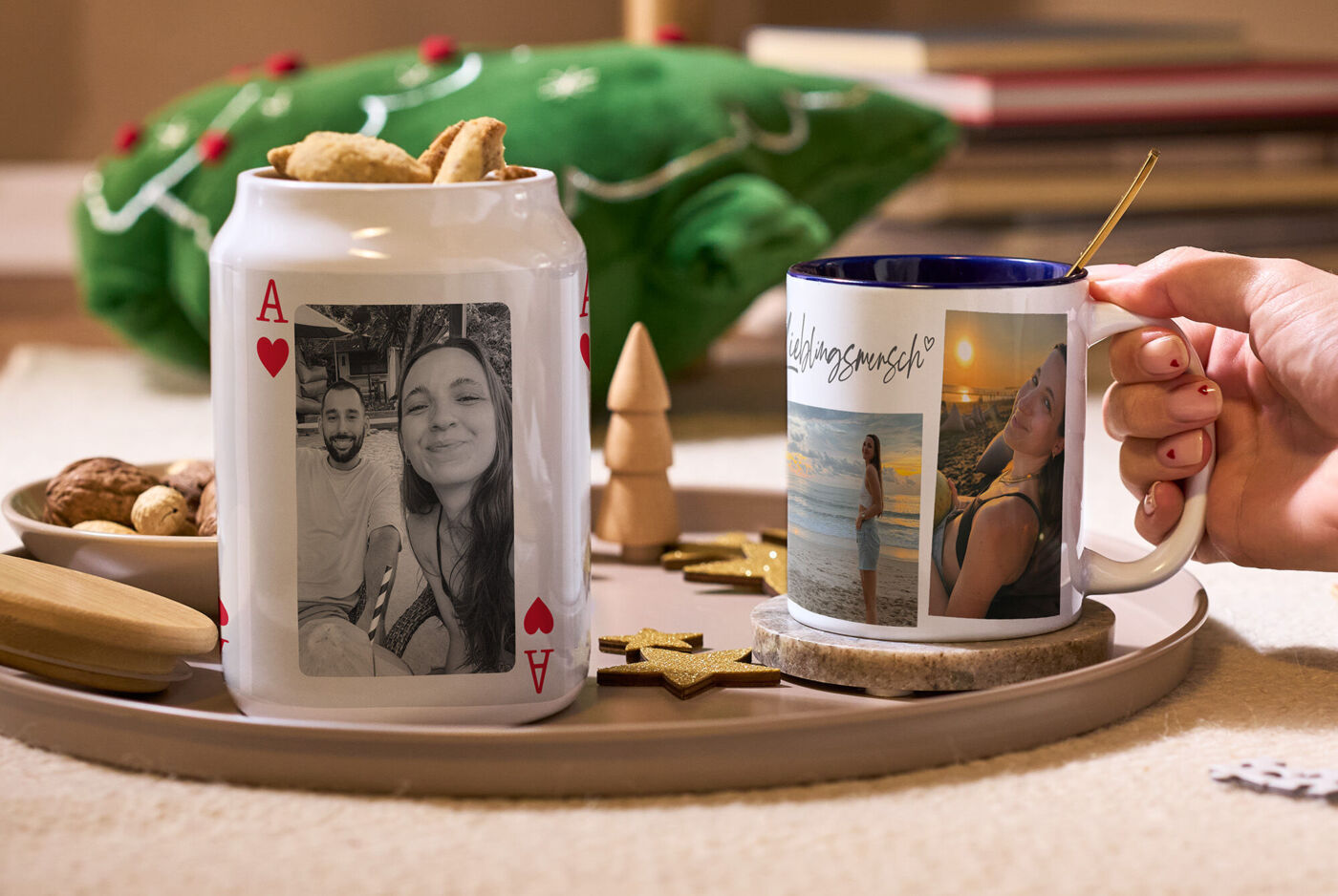 Keksdose und Tasse mit persönlichen Fotos auf einem Tablett neben Weihnachtsdekoration