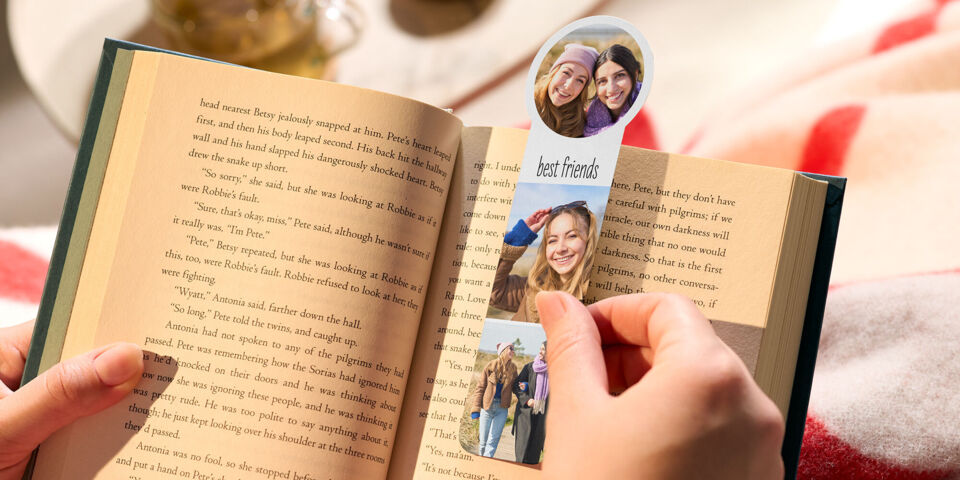 Person hält ein Buch und ein personalisiertes Foto-Lesezeichen mit Bildern von Freundinnen und dem Schriftzug "best friends".