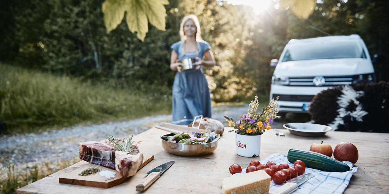Fröhliches Outdoor-Picknick mit frischen Lebensmitteln auf einem Holztisch