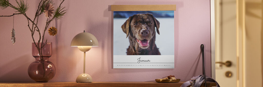 Ein fröhlicher Hund hängt im Kalender für den Monat Januar.