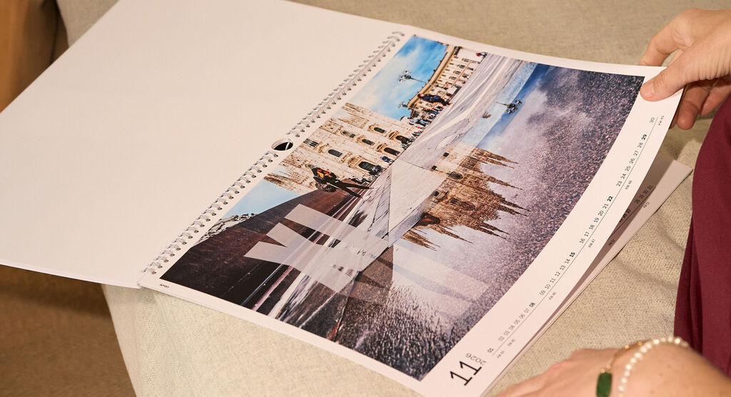 CEWE Fotokalender mit Motiv vom Mailänder Dom und weitem Platz bei Sonnenschein, davor Spiegelung in einer Pfütze.