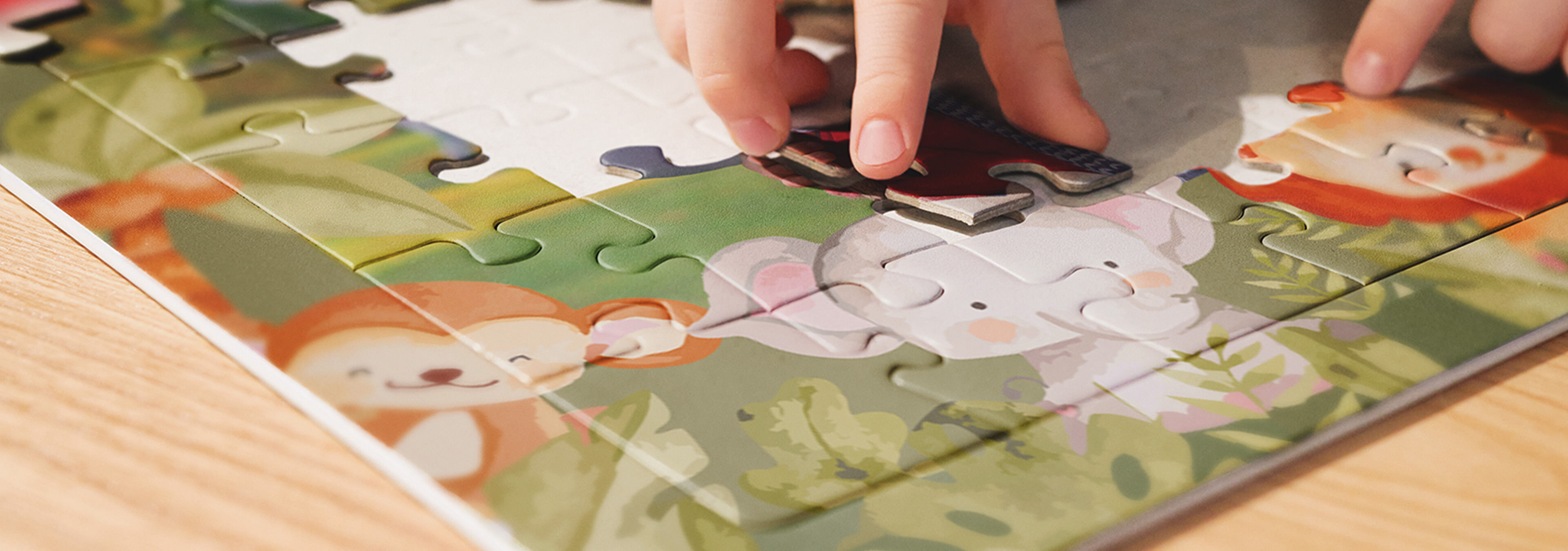 Kind legt ein Fotopuzzle Kids mit Tiermotiv zusammen.