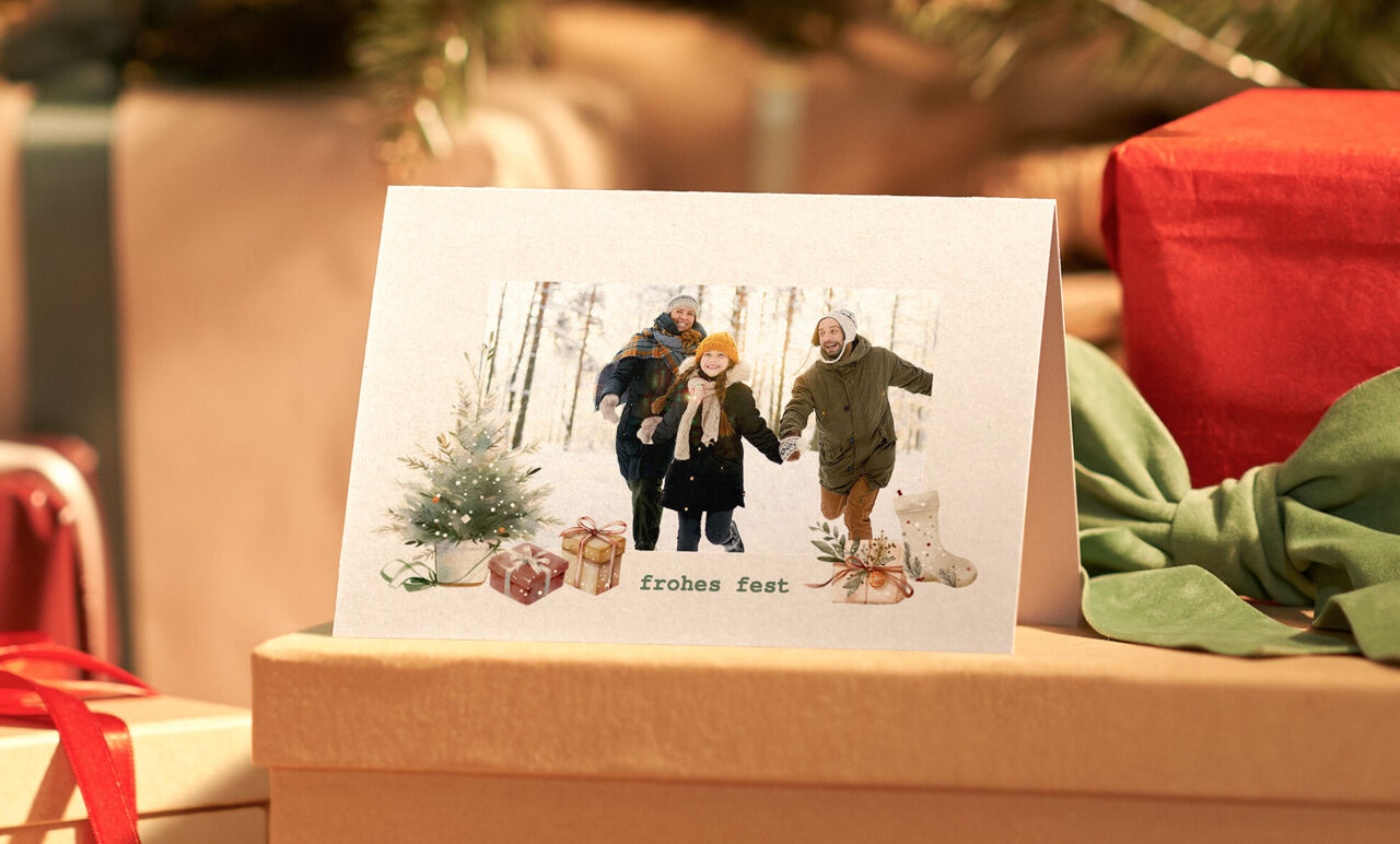 Eine fröhliche Familie mit Weihnachtskarte und Geschenken.