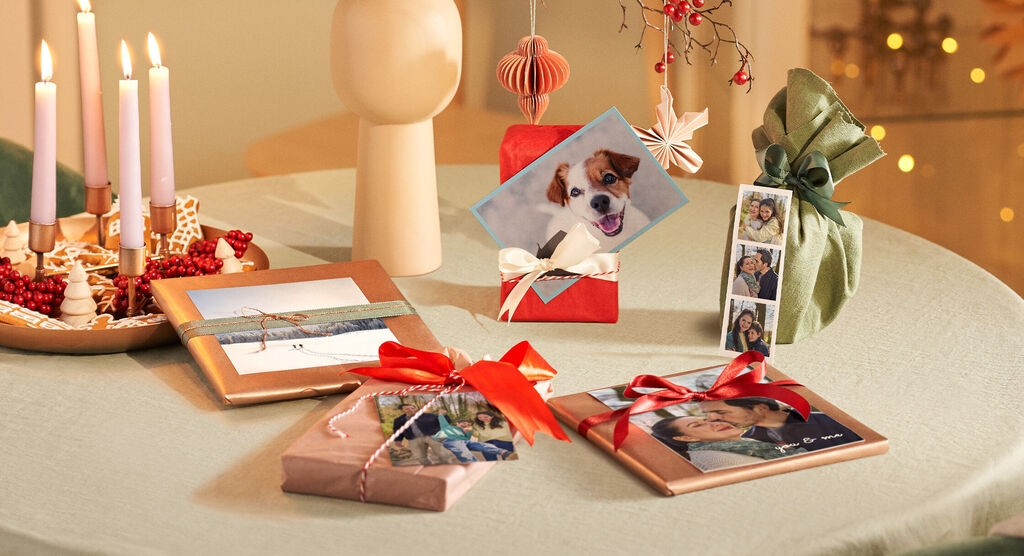 Schöne Geschenke mit Fotos und Dekoration auf einem Tisch