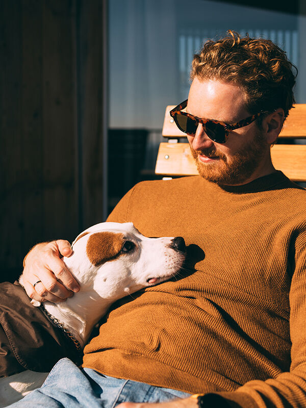 Glücklicher Mensch entspannt mit Hund auf der Terrasse
