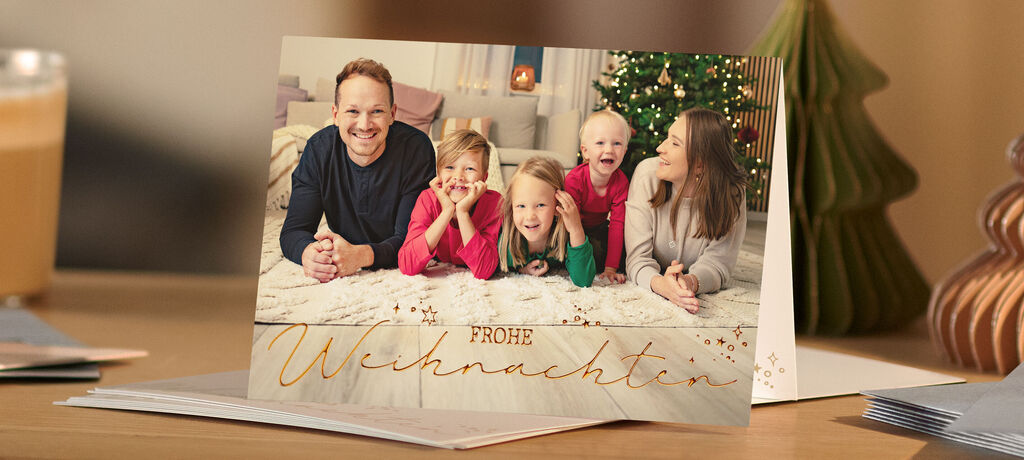 Familie feiert Weihnachten in festlicher Atmosphäre neben dem geschmückten Baum