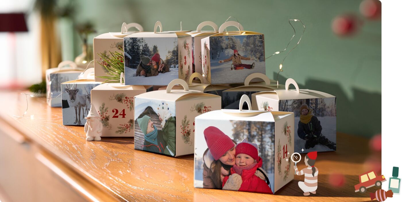 Befüllbarer Adventskalender mit 24 personalisierten Boxen bedruckt mit Familienfotos und weihnachtlichen Motiven auf einem Holztisch.