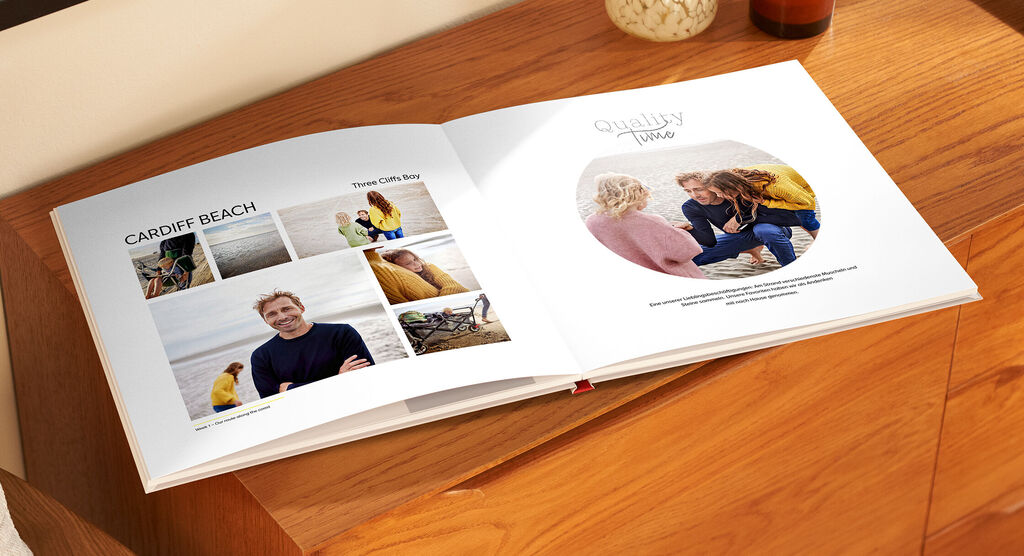 Eine geöffnete CEWE FOTOBUCH mit Fotos von einem Strandurlaub. Die Seiten zeigen fröhliche Momente am Cardiff Beach.