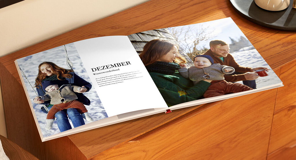 Eine herzliche Familie genießt den Winter mit einem Fotobuch.
